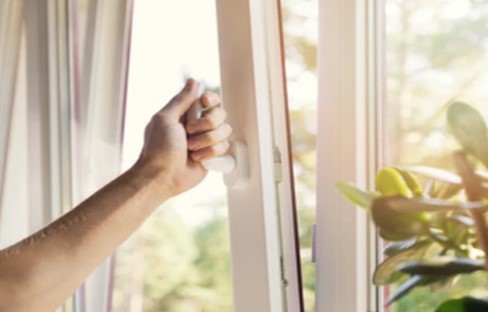 Hand opens window on a sunny day